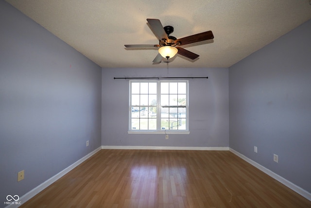 spare room featuring a textured ceiling, light wood-type flooring, and ceiling fan