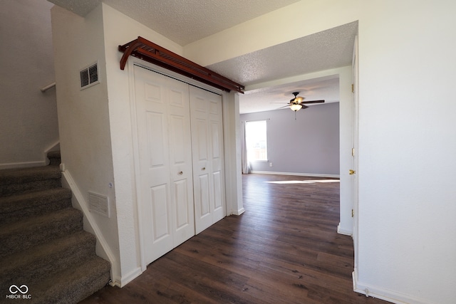 hall featuring a textured ceiling and dark hardwood / wood-style flooring