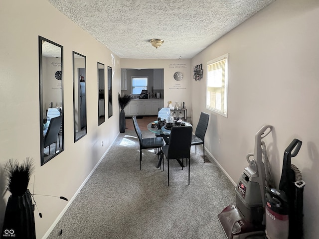 dining area featuring a textured ceiling and carpet flooring