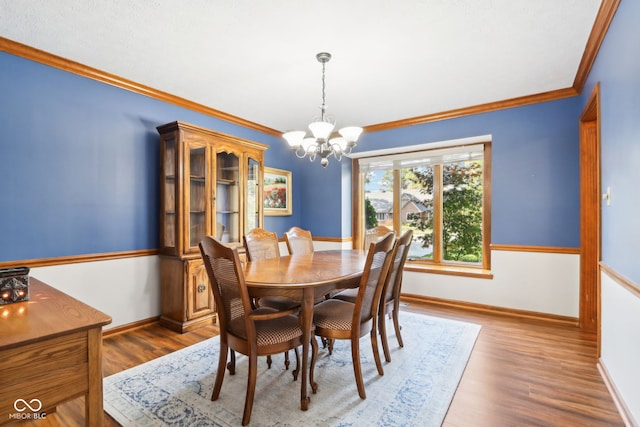 dining space with crown molding, an inviting chandelier, and dark hardwood / wood-style floors