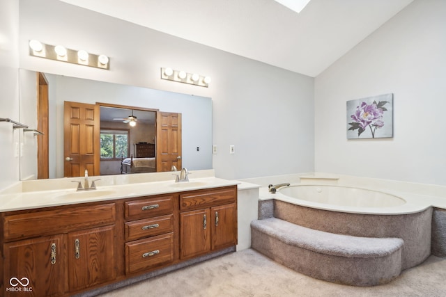 bathroom featuring vanity, a relaxing tiled tub, ceiling fan, and vaulted ceiling