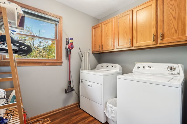 clothes washing area featuring dark wood-type flooring, independent washer and dryer, a textured ceiling, and cabinets