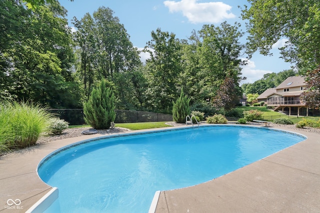 view of pool featuring a wooden deck and a diving board