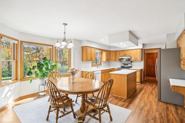 dining space with dark wood-type flooring, sink, and an inviting chandelier