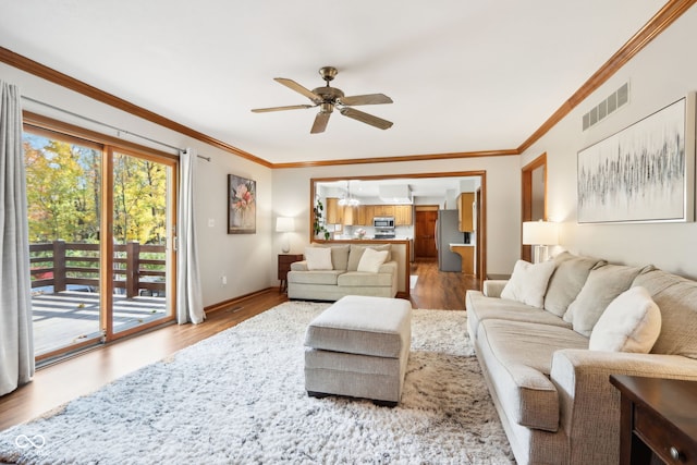 living room featuring light hardwood / wood-style flooring, crown molding, and ceiling fan