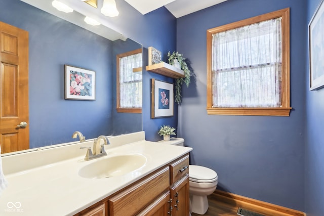 bathroom featuring vanity, toilet, and wood-type flooring