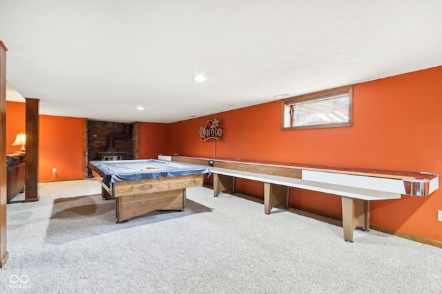 rec room featuring billiards, light carpet, and a wood stove