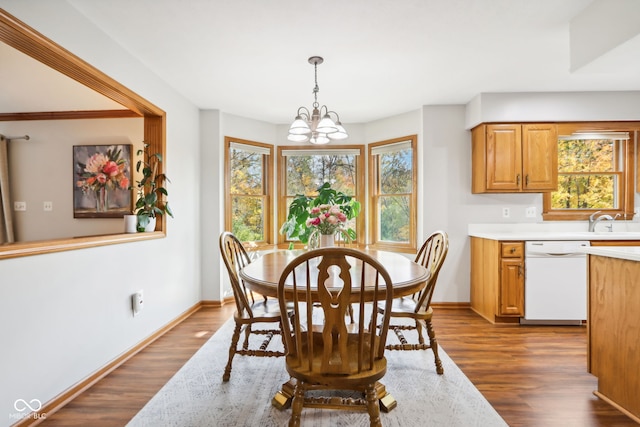 dining room featuring sink, a chandelier, and dark hardwood / wood-style flooring