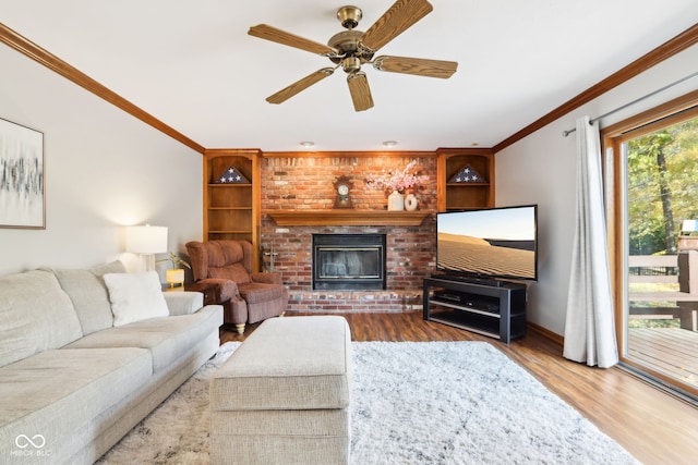 living room featuring crown molding, a fireplace, hardwood / wood-style flooring, and ceiling fan