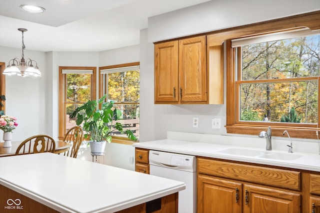 kitchen with an inviting chandelier, sink, white dishwasher, and a wealth of natural light