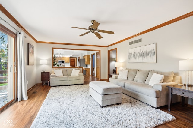 living room with hardwood / wood-style floors, crown molding, and ceiling fan