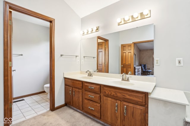 bathroom with toilet, vanity, and tile patterned floors