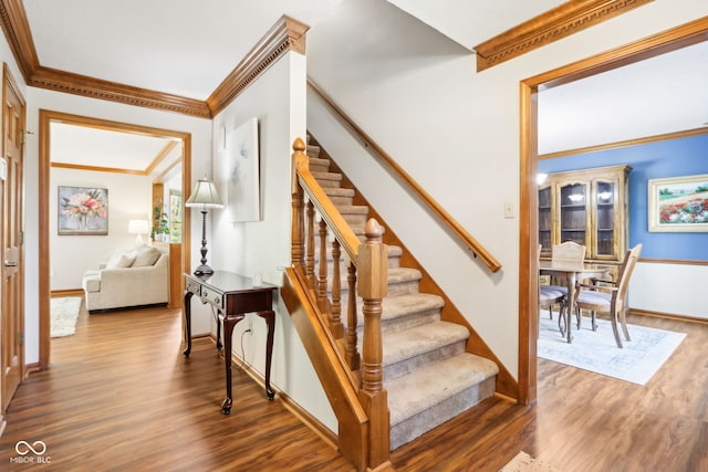 stairs featuring ornamental molding and wood-type flooring