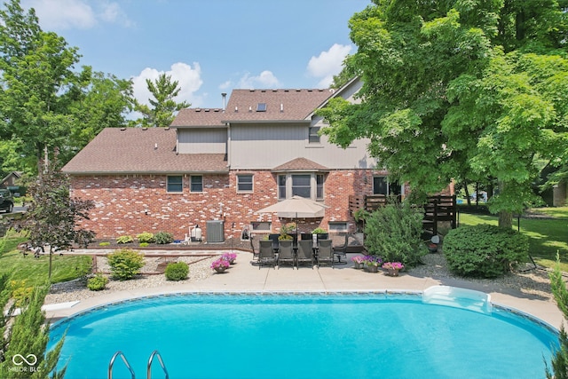 view of pool with central air condition unit, a patio area, and a diving board