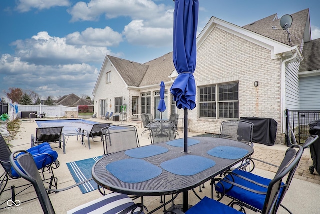 view of patio featuring a fenced in pool and area for grilling