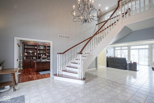 entryway featuring a notable chandelier, light hardwood / wood-style floors, and a high ceiling