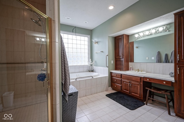 bathroom with tile patterned floors, vanity, and shower with separate bathtub