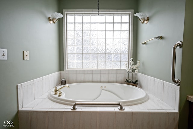 bathroom with tiled bath and a healthy amount of sunlight