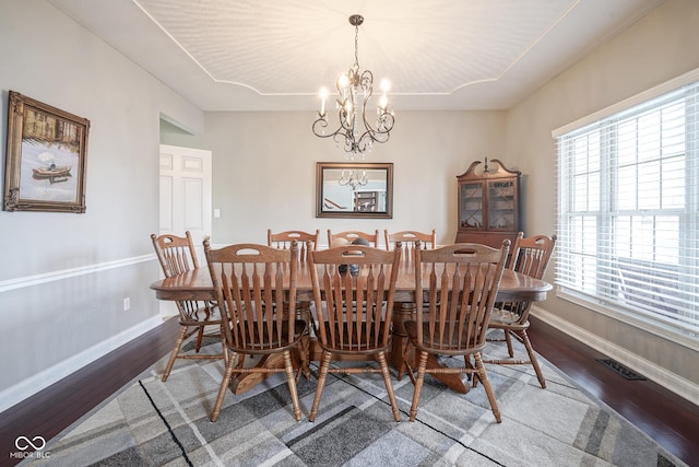 dining area featuring hardwood / wood-style floors and a notable chandelier