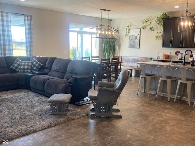 living room featuring a notable chandelier, a textured ceiling, and sink