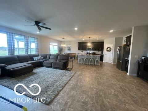 living area with a ceiling fan and recessed lighting