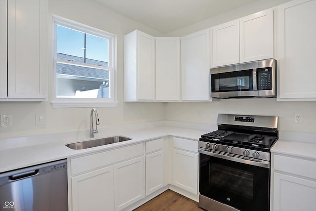 kitchen featuring dark wood-type flooring, stainless steel appliances, sink, and white cabinets