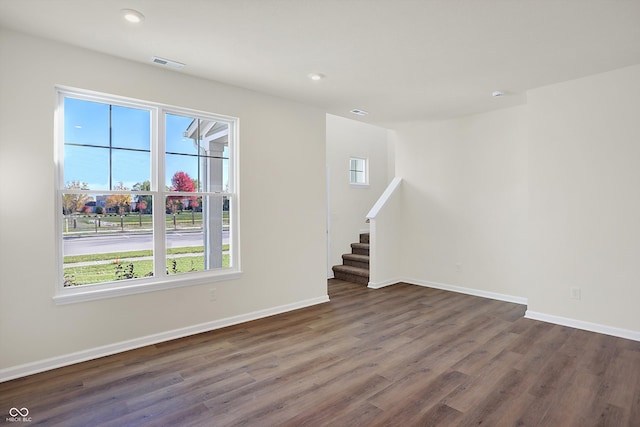 unfurnished room with a wealth of natural light and dark hardwood / wood-style floors