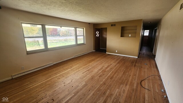 2620 Wicker Rd, Indianapolis, IN 46217 - unfurnished room with hardwood / wood-style flooring, a textured ceiling, and baseboard heating