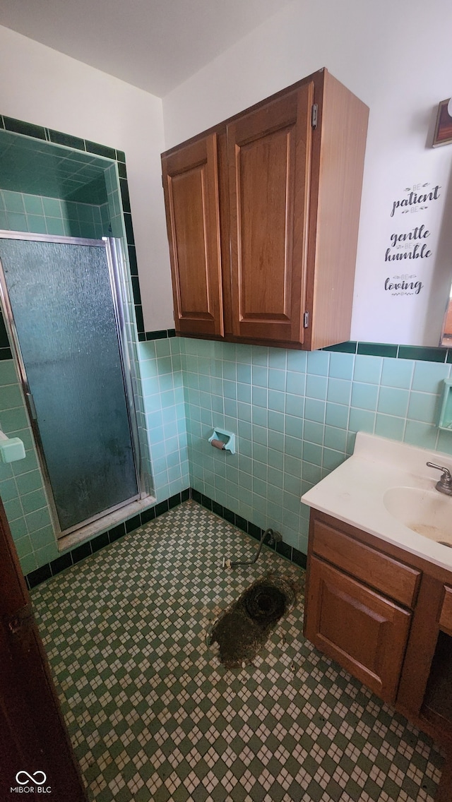 2620 Wicker Rd, Indianapolis, IN 46217 - bathroom featuring vanity, tile walls, tile patterned flooring, and an enclosed shower