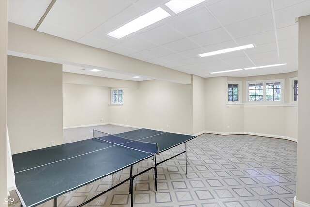 rec room featuring a paneled ceiling and baseboards