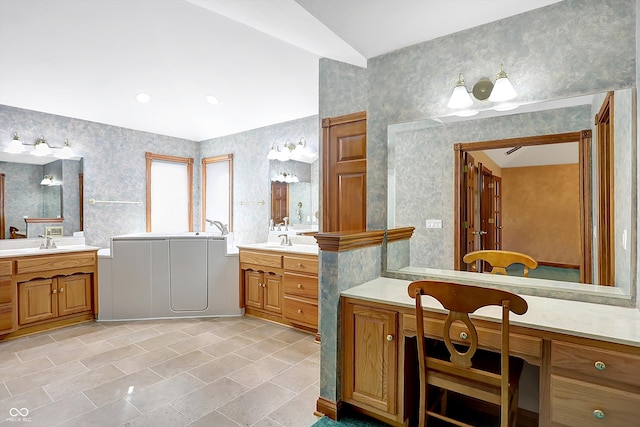 full bath with lofted ceiling, two vanities, and a sink