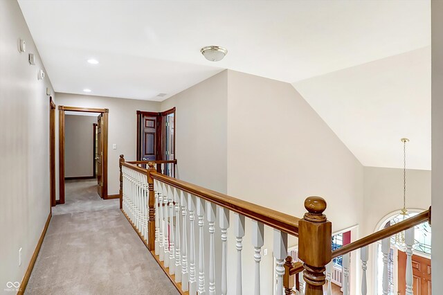 hallway with recessed lighting, light carpet, vaulted ceiling, an upstairs landing, and baseboards