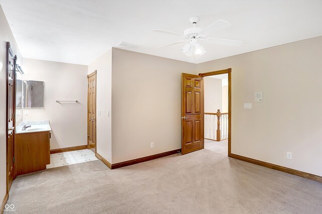 unfurnished bedroom with ceiling fan, light colored carpet, and sink