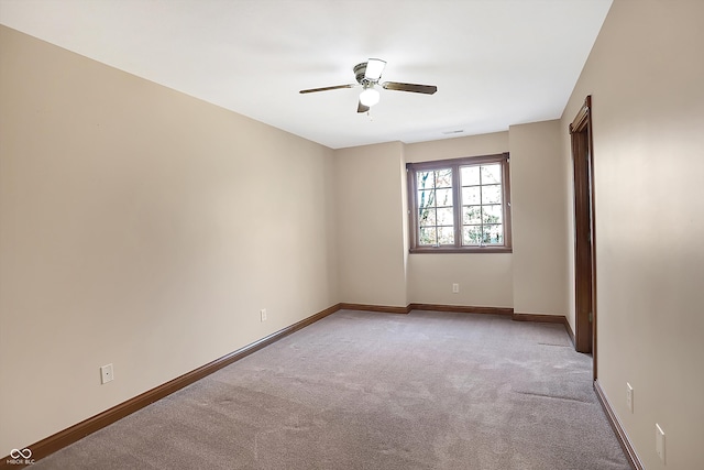 spare room featuring baseboards, ceiling fan, and light colored carpet