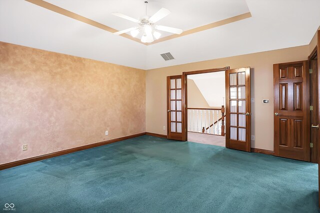 unfurnished room with french doors, ceiling fan, a raised ceiling, and dark carpet