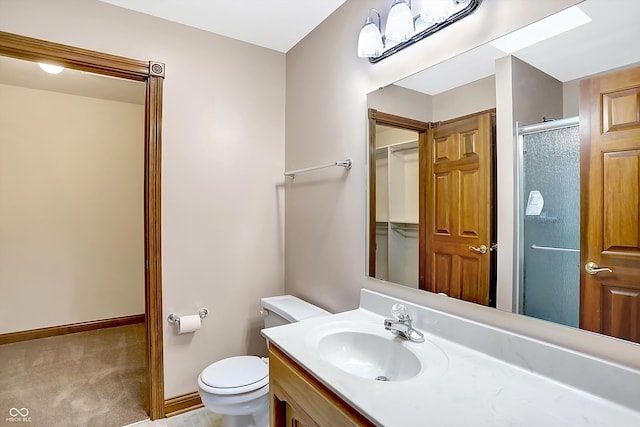 bathroom with toilet, vanity, baseboards, and an enclosed shower