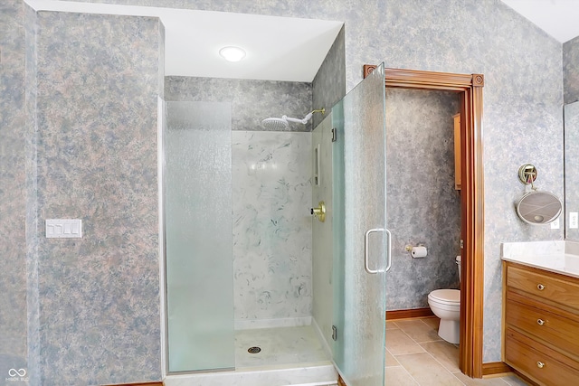 full bathroom with wallpapered walls, toilet, tile patterned flooring, vanity, and a shower stall