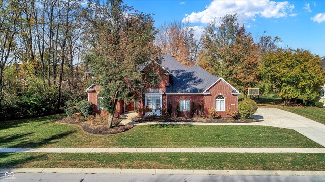 traditional home featuring a front lawn and brick siding