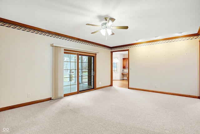 empty room featuring light carpet, crown molding, baseboards, and ceiling fan