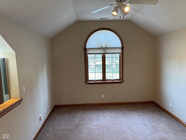 carpeted spare room with a ceiling fan, lofted ceiling, visible vents, and baseboards