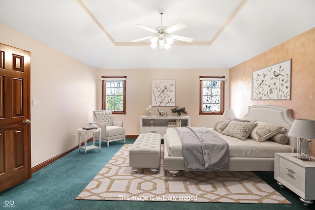 bedroom with ceiling fan, baseboards, a raised ceiling, and carpet flooring