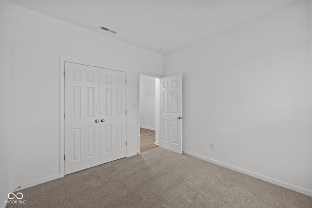 unfurnished bedroom featuring carpet flooring and a closet