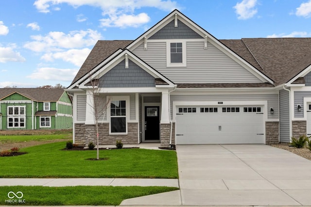 craftsman house with a garage and a front lawn