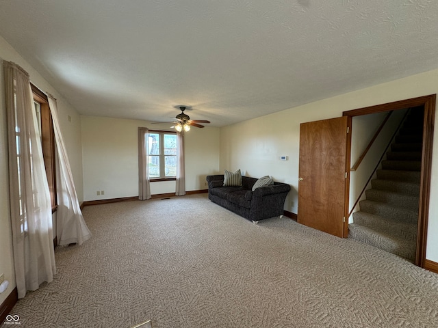 carpeted living room featuring a textured ceiling and ceiling fan