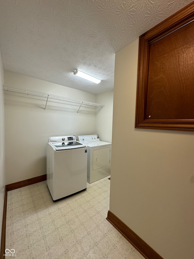 laundry room with washing machine and dryer and a textured ceiling