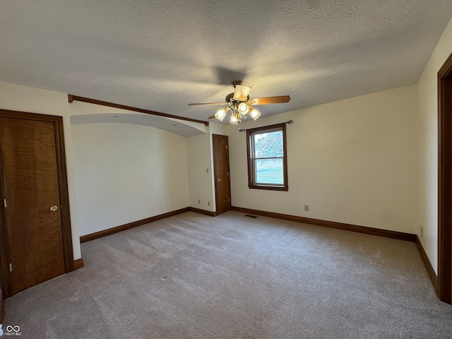 unfurnished room with a textured ceiling, light colored carpet, and ceiling fan