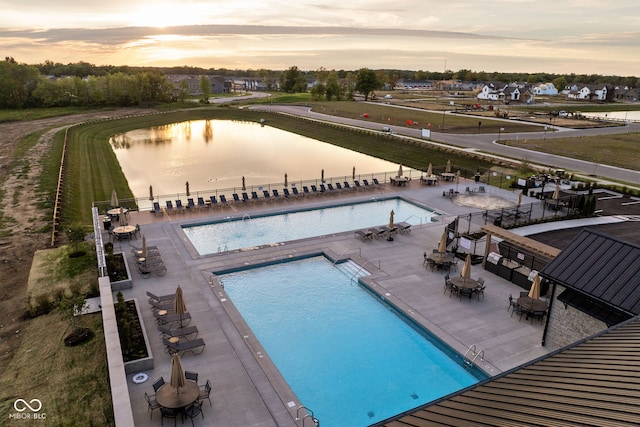 pool at dusk featuring a patio area