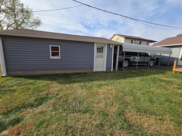 rear view of house with a yard and a carport