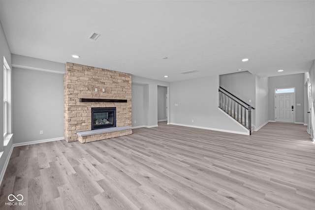 unfurnished living room featuring light wood-type flooring and a fireplace