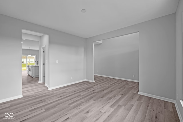 unfurnished room featuring light hardwood / wood-style flooring and sink